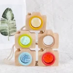 Conjunto de cinco câmeras de madeira com detalhes coloridos, diferentes ângulos e pormenores, em uma disposição empilhada sobre uma superfície clara.