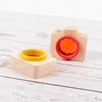 Peças de madeira com formas circulares, uma amarela e uma vermelha, encaixadas em bases de madeira, com fundo de superfície de madeira clara.