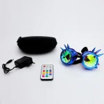Óculos de ciência com lentes espelhadas coloridas, spikes azuis, controle remoto e estojo preto ao lado, sobre fundo branco.