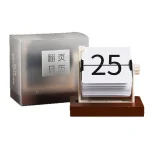 Calendário de mesa com páginas rotativas mostrando o número 25, com caixa de armazenamento ao lado, em ambiente de escritório.