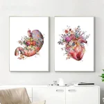 Duas molduras com ilustrações de um estômago e um coração, ambos decorados com flores coloridas e detalhes artísticos, penduradas numa parede branca.