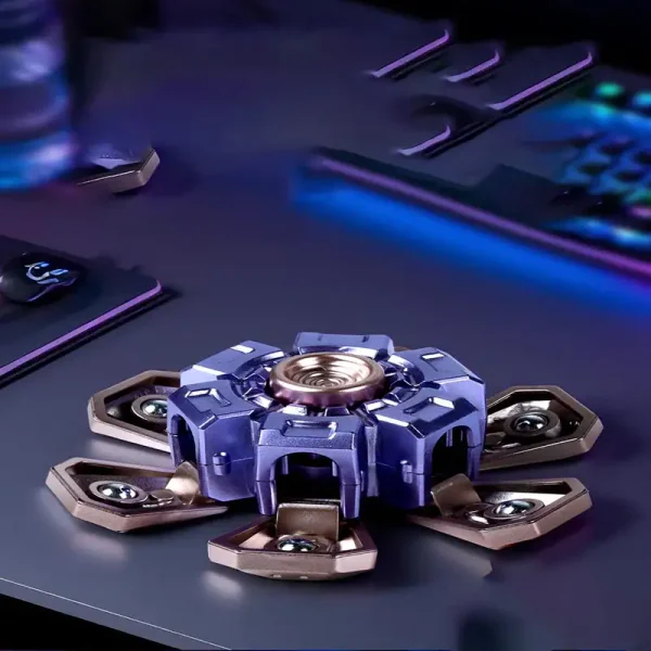 Fidget spinner com estrutura metálica e detalhes em azul e bronze, colocado numa superfície escura com acessórios tecnológicos ao fundo.