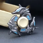 Fidget spinner com quatro lobos estilizados em metal escuro com detalhes azuis, em forma circular com centro de rotação.