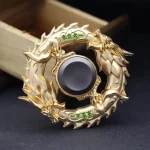 Peça decorativa de dragão com detalhes dourados, com escamas e cabeça de dragão, em forma circular, com inscrição em caracteres chineses verdes.