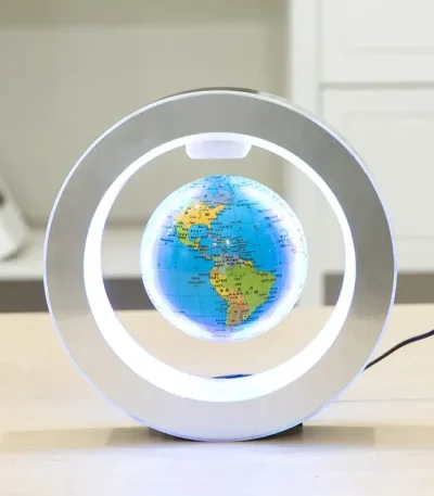 Globo terrestre em miniatura suspenso dentro de uma lâmpada de plasma, com luzes brilhantes ao redor, sobre uma mesa de madeira.