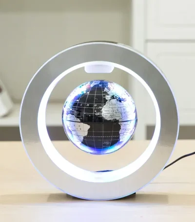 Relógio de mesa com esfera de globo terrestre iluminada e moldura metálica circular.