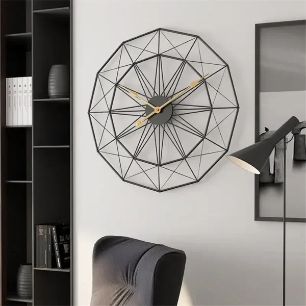 Relógio de parede com estrutura metálica preta em forma de geometria complexa, com ponteiros dourados, numa sala moderna com estante e cadeira de escritório.