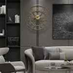 Relógio de parede com estrutura metálica dourada, design geométrico, em sala moderna com sofá cinza e decoração minimalista.