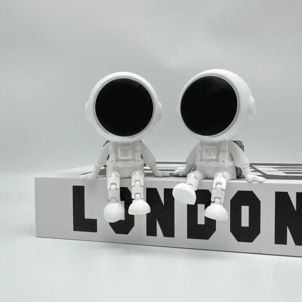 Duas figuras de astronautas em estilo minimalista, com cabeças grandes e corpos pequenos, sentados numa placa com a palavra 'LONDON' em letras pretas.