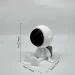 Robô de brinquedo com cabeça grande, corpo pequeno, sentado, com mochila, medido com linhas de dimensão.