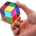 Mão segurando um cubo mágico com cores vibrantes, vista de perto, mostrando detalhes das faces coloridas e a estrutura do puzzle.