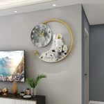 Relógio de parede com design de astronauta e lua, decorando uma parede cinzenta moderna, com detalhes em dourado e uma planta ao lado.