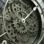 Mecanismo de relógio com engrenagens de metal visíveis, mostrando detalhes internos e movimento.