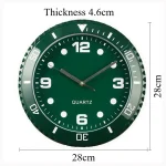 Relógio de parede verde com números brancos, ponteiros prateados e marcações de minutos, dimensões de 28cm de diâmetro e 4.6cm de espessura.