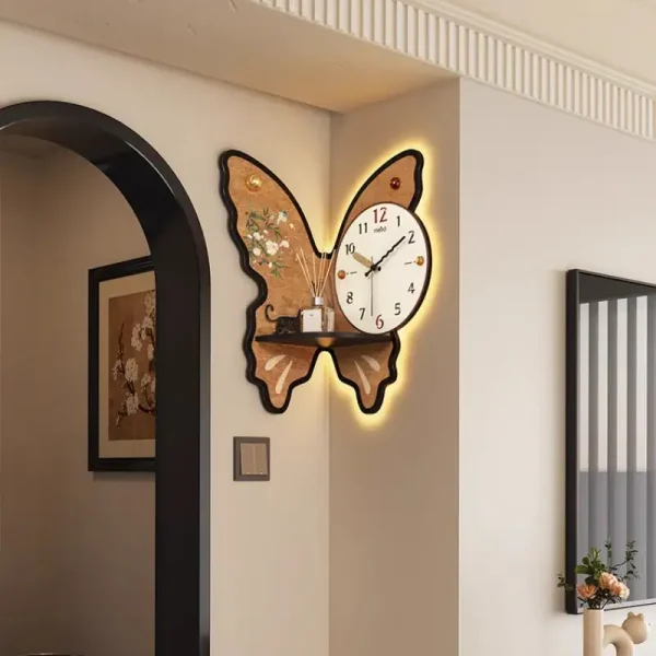 Relógio de parede com forma de borboleta, com iluminação de fundo e detalhes decorativos, instalado numa parede branca ao lado de uma porta de arco.