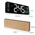 Relógio digital de parede com grande display LED mostrando hora, dia da semana e temperatura, com embalagem de papelão.