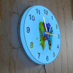 Relógio de parede azul com pintura de um mapa do mundo em cores vibrantes e números coloridos, visto de lado na parede de mármore.