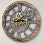 Relógio de parede com estrutura de madeira e engrenagens de metal visíveis, mostrando detalhes do mecanismo interno e ponteiros em movimento.