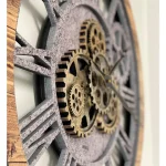 Relógio de parede com engrenagens de metal visíveis, moldura de madeira e detalhes industriais, mostrando o mecanismo interno em destaque.
