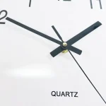Relógio de parede com ponteiros pretos e números grandes, mostrando a hora 3:10, com mecanismo de quartzo visível na parte central.