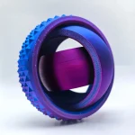 Anel de metal roxo com superfície texturizada em padrão triangular, mostrando detalhes de perto e uma parte interna lisa com acabamento brilhante.