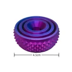 Cilindro de metal roxo e azul com textura em relevo, medindo 4,5cm de diâmetro, usado em experimentos científicos ou como peça decorativa.