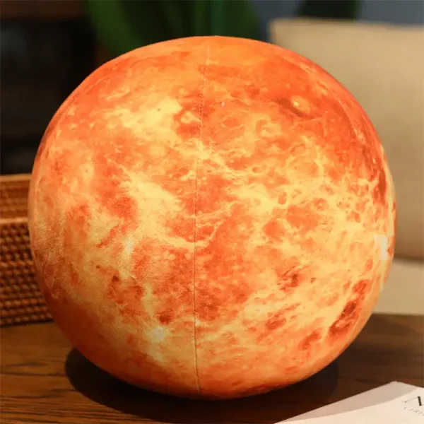 Lâmpada decorativa em forma de planeta Marte com detalhes de superfície e cores vermelhas e laranjas, colocada sobre uma mesa de madeira.