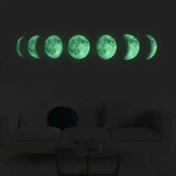 Sequência de fases da Lua iluminada com luz verde, desde a Lua nova até à Lua cheia, exibida numa parede escura.