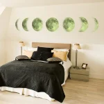 Fase da lua representada por imagens de diferentes fases na parede acima da cama, com iluminação suave ao lado de cada lâmpada de mesa.