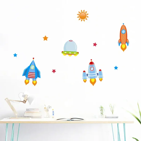 Adesivos de foguetes espaciais coloridos e estrelas na parede de um escritório ou sala de estudo.