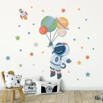 Ilustração de astronauta a segurar balões com planetas e estrelas ao fundo, decorando uma parede de quarto infantil.