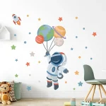 Ilustração de astronauta segurando balões com planetas e estrelas ao redor na parede de um quarto infantil.