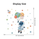 Decoração de parede com astronauta, planetas, estrelas e foguete em estilo infantil.