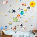Ilustração de planetas do sistema solar, foguetes, estrelas e astronautas na parede acima de uma cama de criança.