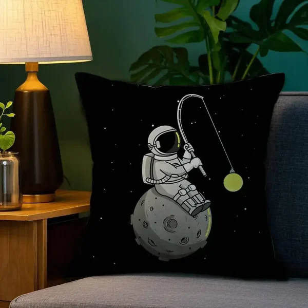 Almofada preta com desenho de astronauta sentado na Lua, segurando uma vara de pesca com uma estrela como isca, fundo estrelado.