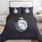Conjunto de roupa de cama com ilustração de planeta e estrelas em fundo escuro, incluindo almofadas e edredon.