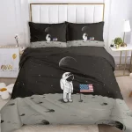 Conjunto de roupa de cama com estampa de astronauta, lua, estrelas e bandeira dos EUA em fundo preto e cinza.