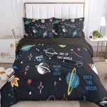 Conjunto de roupa de cama com desenhos de planetas, estrelas e foguetes em fundo escuro, incluindo duas almofadas com padrão semelhante.
