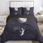 Conjunto de roupa de cama com estampa de astronauta, lua e estrelas em fundo escuro, ideal para quartos infantis com tema de espaço.