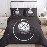 Conjunto de roupa de cama com ilustração de lua e estrelas em fundo preto, incluindo lençol, fronha e edredon, decorando uma cama moderna.