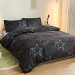 Roupa de cama preta com padrão de estrelas azuis e pontos brancos, vista de cima, em quarto moderno com iluminação suave e decoração minimalista.