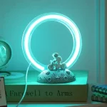 Lâmpada de plasma com anel luminoso azul e base decorativa com tema lunar e astronauta em miniatura.