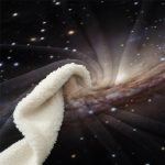 Manta de tecido com padrão de galáxia, mostrando estrelas e nebulosas, com uma parte de tecido branco ao lado.