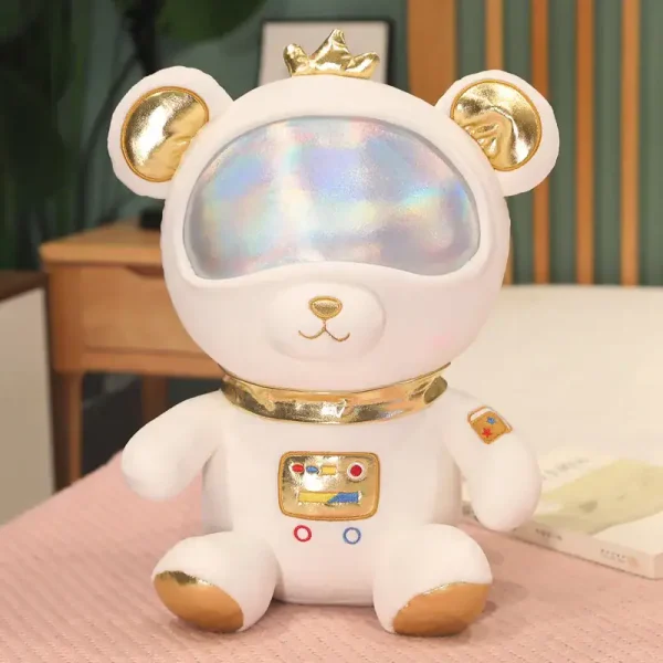 Urso de pelúcia branco com visor holográfico, detalhes dourados e uma pequena coroa dourada na cabeça, sentado numa mesa de madeira.