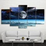 Painel de cinco painéis com imagem do espaço, incluindo a Lua, estrelas e galáxias, colocado numa parede branca acima de um sofá branco.