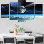 Quadro de cinco painéis com imagem do espaço, incluindo a lua, estrelas, galáxias e a Terra vista do espaço, decorando uma parede branca.