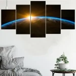 Painel de cinco painéis com imagem da Terra vista do espaço, com o Sol nascente ao fundo, decorando uma parede branca moderna.