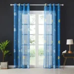 Cortinas de cetim azul com padrão de estrelas e luas, penduradas numa janela grande com moldura branca, com vista para o exterior.