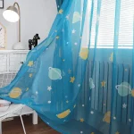Cortina de tecido azul com desenhos de planetas, estrelas e satélites, pendurada na janela de um quarto infantil decorado com tema espacial.
