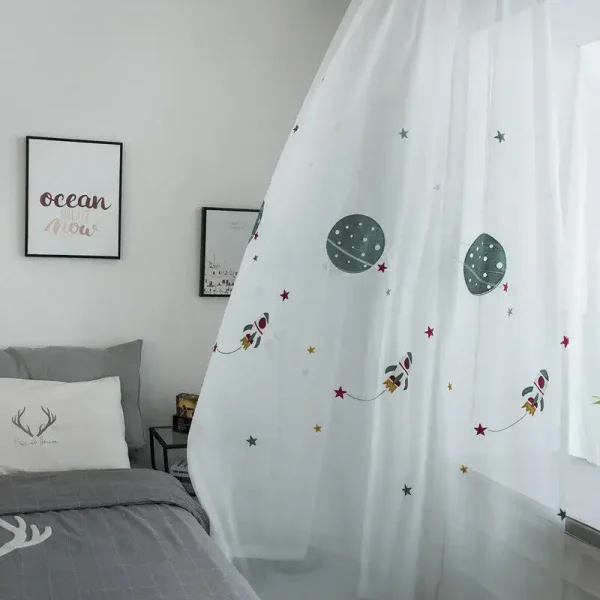 Cortina branca com desenhos de planetas, estrelas e foguetes coloridos, decorando uma janela de quarto infantil.
